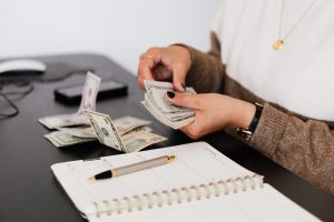 a woman counting money to pay bail amount