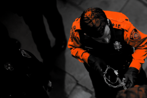 Police officer arresting someone orange black and white
